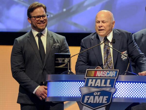 FILE - Hall of Fame inductee Bruton Smith entertains the crowd as his son, Marcus Smith, left, looks on during NASCAR Hall of Fame Induction ceremonies in Charlotte, N.C., Saturday, Jan. 23, 2016.  Bruton Smith, a North Carolina native and entrepreneur who fell in love with auto racing and parlayed it into a career as an eccentric and successful promoter, died Wednesday, June 22, 2022 of natural causes. He was 95. His death was confirmed by Speedway Motorsports, the company he founded and owns and operates 11 race tracks across the United States. (AP Photo/Mike McCarn, File)