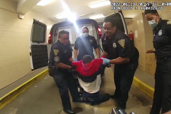 FILE - In this image taken from police body camera video provided by New Haven Police, Richard "Randy" Cox, center, is pulled from the back of a police van and placed in a wheelchair after being detained by New Haven Police on June 19, 2022, in New Haven, Conn. The five former Connecticut police officers who were arrested for allegedly mistreating Cox, then a prisoner, after he was paralyzed in the back of a police van, applied Wednesday, Sept. 13, 2023, for a probation program that could result in the charges being erased.(New Haven Police via AP, File)