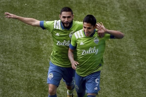 Seattle Sounders forward Raul Ruidiaz, right, celebrates with midfielder Alex Roldan, left, after scoring during second half of an MLS soccer match against the Portland Timbers in Portland, Ore., Sunday, May 9, 2021. (AP Photo/Steve Dykes)