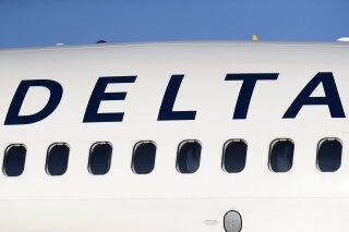 FILE - In this June 26, 2019, file photo, the company logo graces the side of a Delta Air Lines jetliner at Denver International Airport in Denver. Shares of Latam Airlines Group are soaring after Delta Air Lines announced it will pay $1.9 billion for a 20% stake in the operator of South American carriers. (AP Photo/David Zalubowski, File)