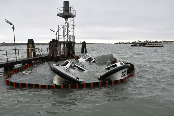 Partially submerged ferry boats in Venice, Italy, Wednesday, Nov. 13, 2019. The mayor of Venice is blaming climate change for flooding in the historic canal city that has reached the second-highest levels ever recorded, as another exceptional water level was recorded Wednesday. (AP Photo/Luigi Costantini)