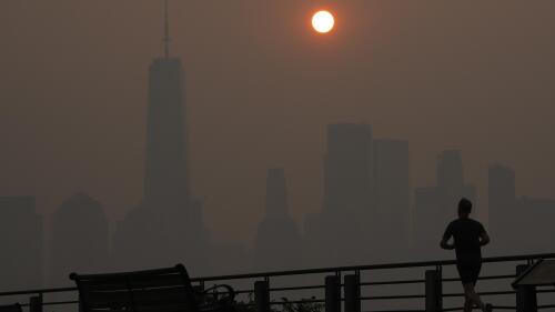 FILE - A man runs in front of the sun rising over the lower Manhattan skyline in Jersey City, N.J., June 8, 2023. Thick, smoky air from Canadian wildfires made for days of misery in New York City and across the U.S. Northeast this week. But for much of the rest of the world, breathing dangerously polluted air is an inescapable fact of life — and death. (AP Photo/Seth Wenig, File)
