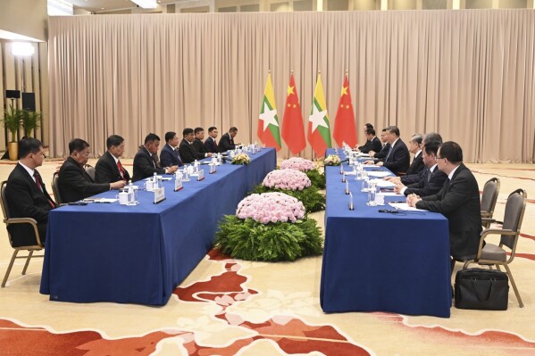 In this photo provided by Myanmar Military True News Information Team on May 9, 2025, Myanmar military chief Senior Gen. Min Aung Hlaing, center left, talks with Chinese President Xi Jinping, center right, during their meeting in Moscow, Russia. (Myanmar Military True News Information Team via AP)