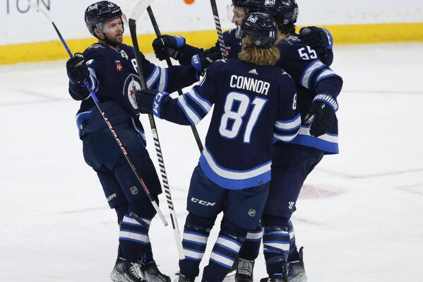 Winnipeg Jets' Josh Morrissey (44), Neal Pionk (4), Kyle Connor (81) and Mark Scheifele (55) celebrate after Scheifele's goal against the Vancouver Canucks during second-period NHL hockey game action in Winnipeg, Manitoba, Thursday, Dec. 29, 2022. (John Woods/The Canadian Press via AP)