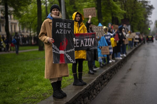 Women hold "Free Azov" signs during a rally aiming to raise awareness on the fate of Ukrainian prisoners of war in Kyiv, Ukraine, Sunday, April 21, 2024. The U.S. House of Representatives swiftly approved $95 billion in foreign aid for Ukraine, Israel and other U.S. allies in a rare Saturday session as Democrats and Republicans banded together after months of hard-right resistance over renewed American support for repelling Russia's invasion. (AP Photo/Francisco Seco)