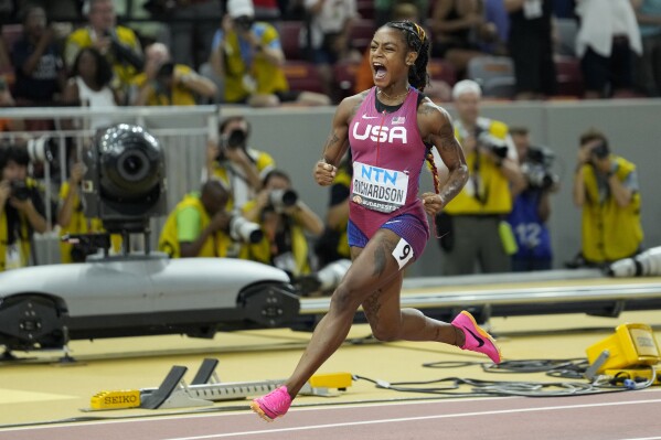 Sha'Carri Richardson, of the United States, reacts after crossing the finish line to win the gold medal in the Women's 100-meter final during the World Athletics Championships in Budapest, Hungary, Monday, Aug. 21, 2023. (AP Photo/Matthias Schrader)