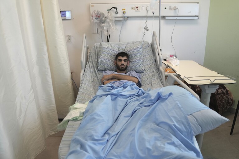 Nader Rimawi recovers in a Ramallah hospital on Sunday, Jan. 7, 2024, after he was wounded by Israeli forces in a shooting last week in the occupied West Bank village of Beit Rima that also injured his brother and killed a 17-year-old. (AP Photo/Mahmoud Illean)