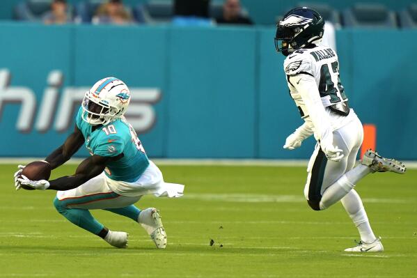 Miami Dolphins wide receiver Tyreek Hill (10) grabs a pass as Philadelphia Eagles safety K'Von Wallace (42) is late with the tag during the first half of a NFL preseason football game, Saturday, Aug. 27, 2022, in Miami Gardens, Fla. (AP Photo/Lynne Sladky)