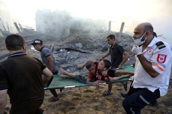 Palestinians evacuate two wounded boys following Israeli airstrikes on Gaza City, Wednesday, Oct. 25, 2023. (AP Photo/Abed Khaled)