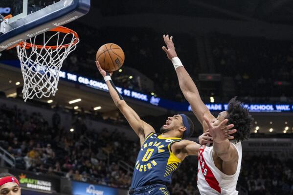 Indiana Pacers guard Tyrese Haliburton (0) shoots while being defended by Toronto Raptors forward Scottie Barnes during the second half of an NBA basketball game in Indianapolis, Monday, Jan. 2, 2023. (AP Photo/Doug McSchooler)