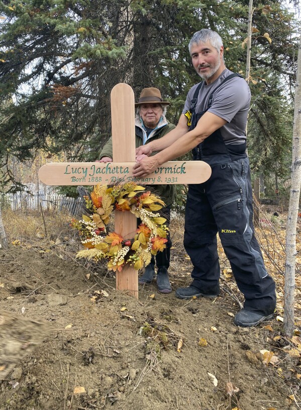In this Sept. 29, 2023, photo, Brian Cruger holds the cross made for the grave of his great-grandmother, Lucy Pitka McCormick, and with him is McCormick's granddaughtger, Kathleen Carlo, during a reburial ceremony in Rampart, Alaska. (Photo by Wally Carlo via AP).