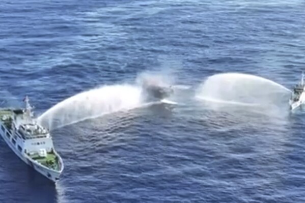 In this image made from video provided by the Philippine Coast Guard, Philippine resupply vessel Unaizah May 4, center, is hit by two Chinese coast guard water canon blasts, causing injuries to multiple crew members as they tried to enter the Second Thomas Shoal, locally known as Ayungin Shoal, in the disputed South China Sea, Tuesday, March 5, 2024. Chinese and Philippine coast guard vessels collided in the disputed South China Sea and multiple Filipino crew members were injured in high-seas confrontations Tuesday as Southeast Asian leaders gathered for a summit that was expected to touch on Beijing's aggression at sea. (Philippine Coast Guard via AP)
