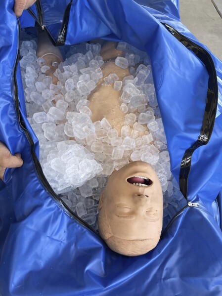 Phoenix Fire Capt. John Prato demonstrates a new protocol that the fire department in America’s hottest big city is adopting as the West braces for the first heat wave of the summer season, Monday, June 3, 2024, in Phoenix. (AP Photo/Anita Snow)
