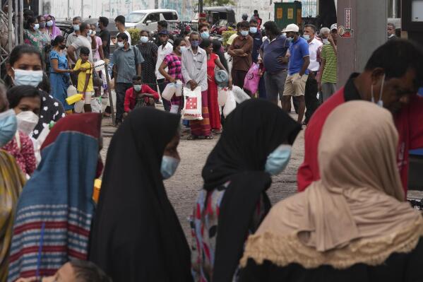 Sri Lankans queue up near a fuel station to buy kerosene in Colombo, Sri Lanka, Tuesday, April 12, 2022. Sri Lanka is suspending its repayment of foreign debt, including bonds and government-to-government borrowings, pending the completion of a loan restructuring program with the International Monetary Fund to deal with the island nation's worst economic crisis in decades, the government said Tuesday. (AP Photo/Eranga Jayawardena)