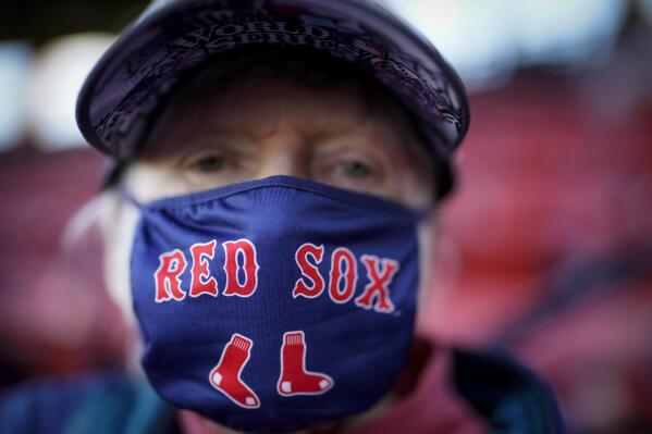 A Boston Red Sox fan wears a face mask before Game 5 of baseball's American League Championship Series against the Houston Astros Wednesday, Oct. 20, 2021, in Boston. (AP Photo/David J. Phillip)