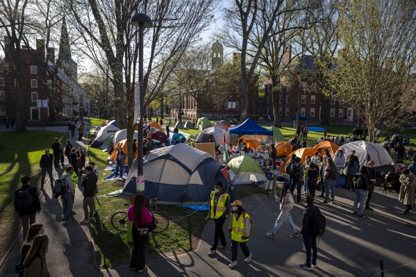 Students protesting against the war in Gaza, and passersby walking through Harvard Yard, are seen at an encampment at Harvard University in Cambridge, Mass., April 25, 2024. (AP Photo/Ben Curtis, File)