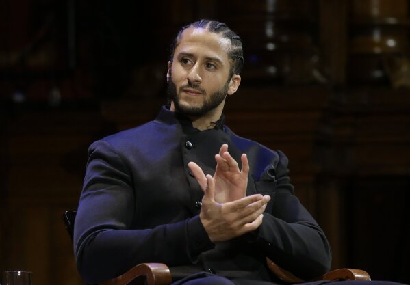 
              Former NFL football quarterback Colin Kaepernick applauds while seated on stage du...