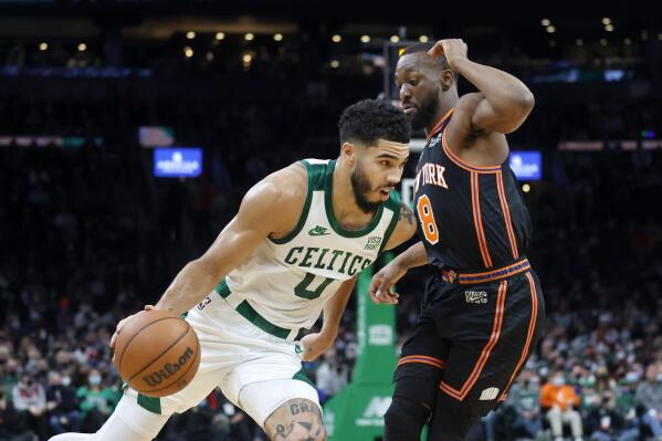 Boston Celtics forward Jayson Tatum (0) drives against New York Knicks guard Kemba Walker (8) during the first half of an NBA basketball game, Saturday, Dec. 18, 2021, in Boston. (AP Photo/Mary Schwalm)