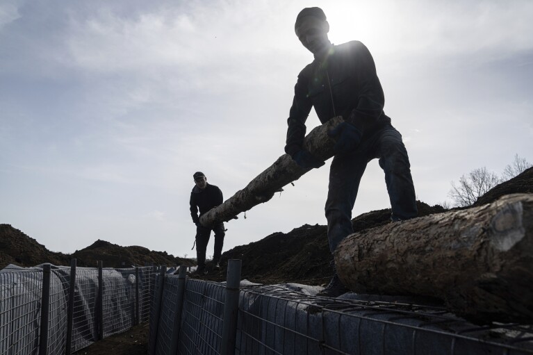 Workers construct new defensive positions close to the Russian border in Kharkiv region, Ukraine, on Wednesday, April 17, 2024. (AP Photo/Evgeniy Maloletka)