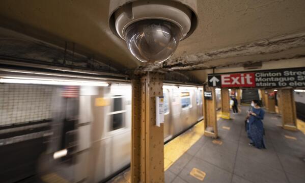FILE - A video surveillance camera hangs from the ceiling above a subway platform, Wednesday, Oct. 7, 2020 in the Brooklyn borough of New York. All subway cars in New York will soon be equipped with security cameras in an effort to keep riders safe and solve crimes happening in train stations, New York Governor Kathy Hochul announced Tuesday, Sept. 20. The Metropolitan Transportation Authority New York City Transit received about $5.5 million in state and federal funding for purchasing and installing cameras on about 6,355 subway cars. (AP Photo/Mark Lennihan, File)