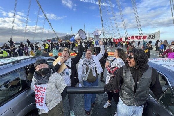 FILE - Demonstrators shut down the San Francisco Oakland Bay Bridge in conjunction with the APEC Summit taking place Thursday, Nov. 16, 2023, in San Francisco. Seventy-eight protesters were ordered Thursday, March 14, 2024, do five hours of community service and pay restitution to avoid criminal proceedings for allegedly blocking traffic on the San Francisco-Oakland Bay Bridge for hours in November to demand a cease-fire in Gaza, prosecutors said. (AP Photo/Noah Berger, File)