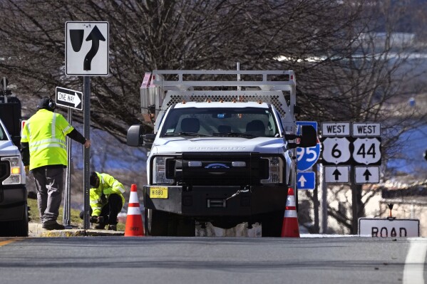 Rhode Island Department of Transportation workers replace a sign leading to the onramp to the Washington Bridge, Friday, March 8, 2024, in East Providence, R.I. (AP Photo/Charles Krupa)
