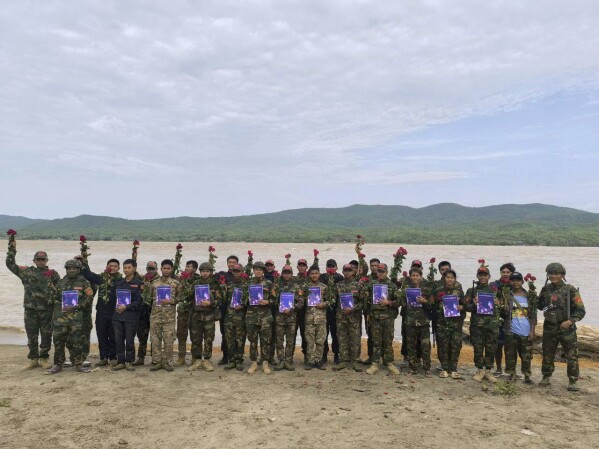 In this photo provided by Thabeikkyin Township People’s Defense Force, the group's members pose for photographs with roses and posters that read ''The steel roses will retaliate against the junta’s oppression without yielding,'' as they celebrate the 79th birthday of the country’s ousted leader Aung San Suu Kyi in Thabeikkyin township in Mandalay region, Myanmar on Wednesday, June 19, 2024. ( Thabeikkyin Township People’s Defense Force via AP)