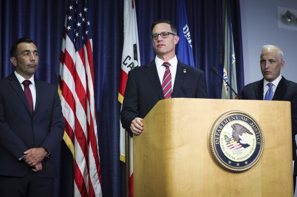 U.S. Attorney Randy S. Grossman for the Southern District of California, center, speaks during a press conference at the U.S. Attorney's Office for the Southern District of California on Thursday, Aug. 3, 2023, in San Diego. Two U.S. Navy sailors have been arrested and accused of providing sensitive military information to China — including details on wartime exercises, Naval operations and critical technical material, federal officials said Thursday. (Meg McLaughlin/The San Diego Union-Tribune via AP)