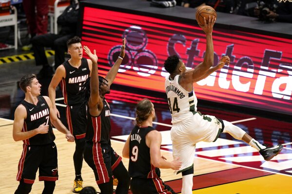 Milwaukee Bucks forward Giannis Antetokounmpo (34) shoots next to Miami Heat forward Kelly Olynyk (9) during the first half of an NBA basketball game Tuesday, Dec. 29, 2020, in Miami. (AP Photo/Lynne Sladky)