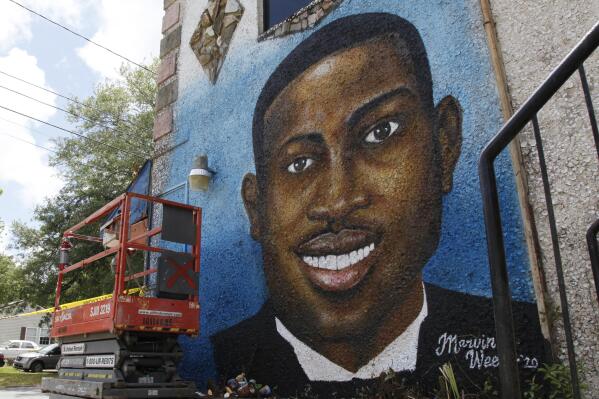 FILE - This May 17, 2020, file photo, shows a mural depicting Ahmaud Arbery in Brunswick, Ga.  Travis McMichael, the man convicted of murder for shooting Ahmaud Arbery is withdrawing his guilty plea on a federal hate crime charge.  McMichael announced his decision Friday, Feb. 4, 2022.  (AP Photo/Sarah Blake Morgan, File)