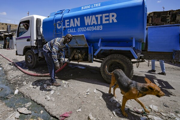 A water vendor fills up reservoir water tanks to be sold to residents in Athi River, Machakos county, Kenya, Tuesday, Oct. 17, 2023. There is no piped water or sewage system in Athi River, near Kenya's capital Nairobi, and drought is making clean water supplies more scarce and expensive for locals. (AP Photo/Brian Inganga)