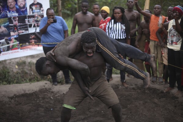 Young Ugandans tangle in the mud. They dream of becoming professional wrestlers