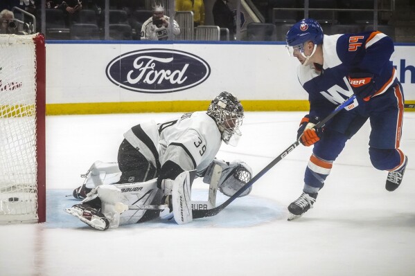 New York Islanders' Jean-Gabriel Pageau, right, scores against Los Angeles Kings' Cam Talbot, left, for an overtime win of an NHL hockey game Saturday, Dec. 9, 2023, in Elmont, N.Y. (APPhoto/Bebeto Matthews)