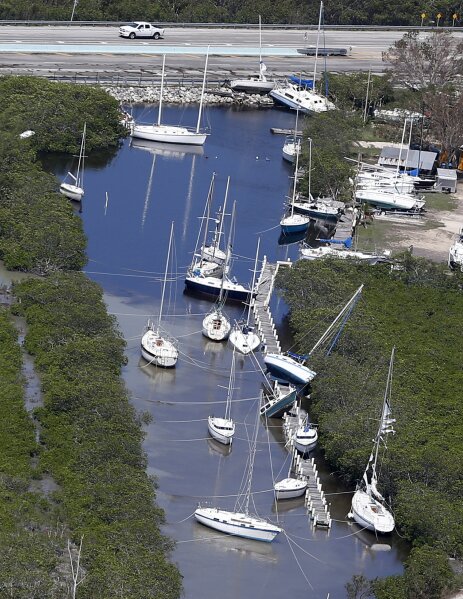 
              Boats, some partially submerged, float in a canal in the wake of Hurricane Irma, Monday, Sept. 11, 2017, in Key Largo, Fla. (AP Photo/Wilfredo Lee)
            