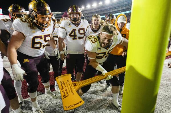 Minnesota linebacker Josh Aune (29) celebrates with the Paul Bunyan's Axe trophy after they beat Wisconsin 23-16 in an NCAA college football game Saturday, Nov. 26, 2022, in Madison, Wis. (AP Photo/Andy Manis)