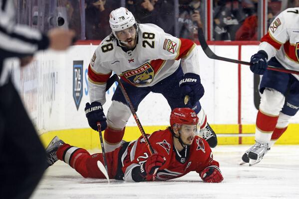 Florida Panthers' Josh Mahura (28) takes Carolina Hurricanes' Sebastian Aho (20) off the puck and to the ice during the third period of Game 2 of the NHL hockey Stanley Cup Eastern Conference finals in Raleigh, N.C., Saturday, May 20, 2023. (AP Photo/Karl B DeBlaker)