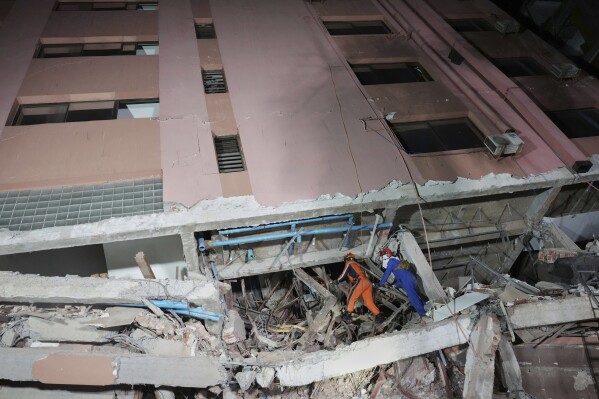 In this photo released by Xinhua News Agency, rescuers search for survivors at a collapsed building in the aftermath of an earthquake in Mandalay, Myanmar on Sunday, March 30, 2025. (Cai Yang/Xinhua via AP)