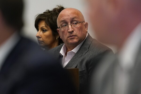 FILE - Robert E. Crimo III's father Robert Crimo Jr., right, and mother Denise Pesina attend to a hearing for their son in Lake County court on Aug. 3, 2022, in Waukegan, Ill. Crimo Jr. has been released early from jail, Wednesday, Dec. 13, 2023 after serving part of a 60-day sentence for sponsoring a firearm application for his son. (AP Photo/Nam Y. Huh, Pool, File)