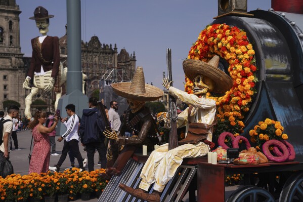 Visitors take photos of Day of the Dead themes presentations at Mexico City´s main square the Zocalo, Tuesday, Oct. 31, 2023. (AP Photo/Marco Ugarte)