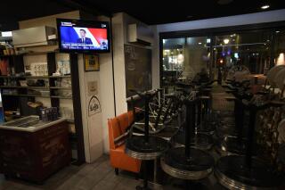The acceptance speech of Emmanuel Macron can be seen on a TV screen in an empty bar in Marseille, southern France after the announcement of projections in the French election runoff, Sunday, April 24, 2022. A French TV channel said a technical error resulted in inaccurate vote tallies being shown during a broadcast. But some on social media falsely suggested the clip was indicative of fraud. (AP Photo/Daniel Cole)