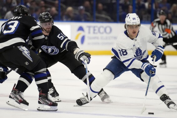Toronto Maple Leafs right wing William Nylander (88) works around Tampa Bay Lightning left wing Austin Watson (51) and left wing Conor Sheary (73) during the first period of an NHL hockey game Wednesday, April 17, 2024, in Tampa, Fla. (AP Photo/Chris O'Meara)