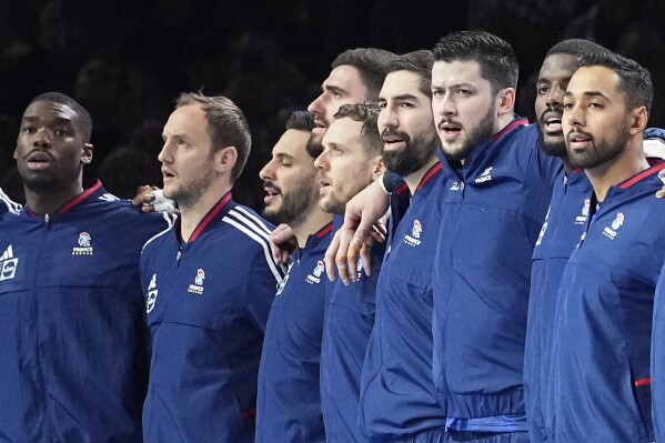 France's Nikola Karabatic, 4th from right, stands with his team during the anthem prior the Handball European Championship main round match between France and Croatia in Cologne, Germany, Thursday, Jan. 18, 2024. (AP Photo/Martin Meissner)