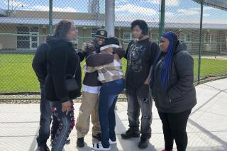 In this photo provided by the State Appellate Defender Office, Terance Calhoun, center, is greeted by family members on Wednesday, April 27, 2022, after his release from a state prison in Whitmore Lake, Mich. Calhoun’s convictions for kidnapping and other crimes were dropped at the request of prosecutors who said evidence showed he’s innocent. He spent 15 years in prison. (Angie Jackson/State Appellate Defender Office via AP)