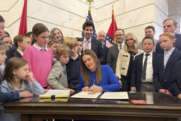 FILE - Arkansas Gov. Sarah Huckabee Sanders signs into law an education overhaul bill, Wednesday, March 8, 2023 at the state Capitol in Little Rock, Ark. The Arkansas Supreme Court on Thursday, Oct. 12, 2023, upheld the procedural vote that allowed Huckabee Sanders' education overhaul to take effect immediately, rejecting a judge's ruling that threw into question the way state laws have been fast-tracked into enforcement over the years. (AP Photo/Andrew DeMillo)