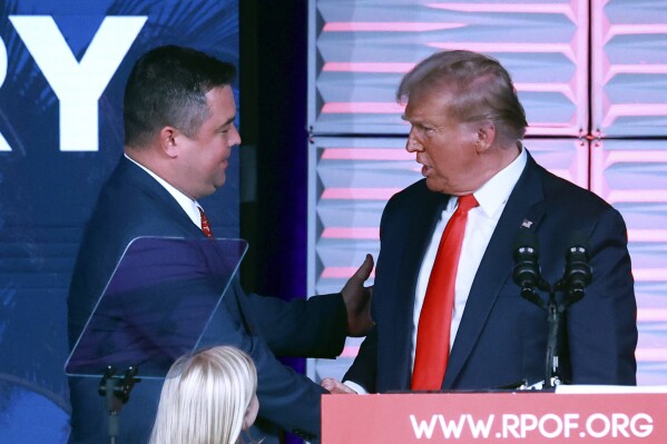 El presidente del Partido Republicano de Florida Christian Ziegler, izquierda, saluda al expresidente Donald Trump en la Cumbre RPOF Freedom, el 4 de noviembre de 2023 en Kissimmee, Florida. (Joe Burbank/Orlando Sentinel vía AP)
