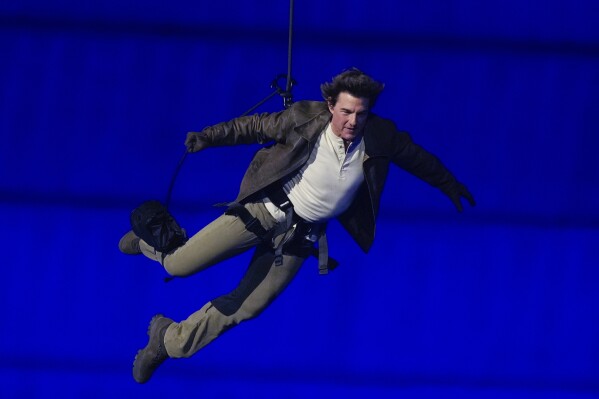Tom Cruise is lowered on the State de France during the 2024 Summer Olympics closing ceremony, Sunday, Aug. 11, 2024, in Saint-Denis, France. (AP Photo/Natacha Pisarenko)