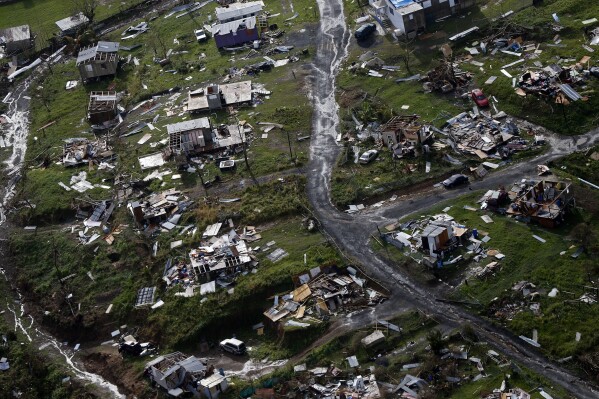 FILE - Destroyed communities are seen in the aftermath of Hurricane Maria in Toa Alta, Puerto Rico, Sept. 28, 2017. With warmer oceans serving as fuel, Atlantic hurricanes are now more than twice as likely as before to rapidly intensify from wimpy minor hurricanes to powerful and catastrophic, a study said Thursday, Oct. 19, 2023. (AP Photo/Gerald Herbert, File)