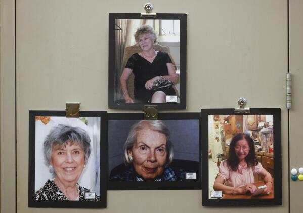 From top photographs of victims Mary Brooks, Martha Williams, Mary Bartel and Lu Thi Harris hang on the door during the third court trial of  Billy Chemirmir at Frank Crowley Courts Building in Dallas on Thursday, Oct. 6, 2022. Chemirmir, 49, is charged with capital murder of 22 elderly people in North Texas. (Shafkat Anowar/The Dallas Morning News via AP)