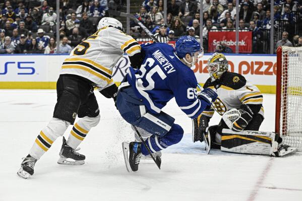 Toronto Maple Leafs' Ilya Mikheyev (65) is knocked down by Boston Bruins' Connor Clifton after going to the net during the second period of an NHL hockey game in Toronto, Friday, April 29, 2022. (Aaron Vincent Elkaim/The Canadian Press via AP)