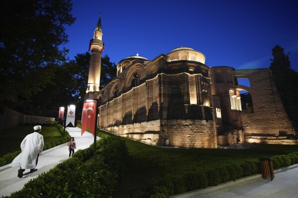 A Muslim cleric walks along a former Byzantine church which formally opened as a mosque, in Istanbul, Turkey, Monday, May 6, 2024. Turkish President Recep Tayyip Erdogan formally opened a former Byzantine church in Istanbul as a mosque on Monday, four years after his government had designated it a Muslim house of prayer, despite criticism from neighboring Greece. (AP Photo/Emrah Gurel)